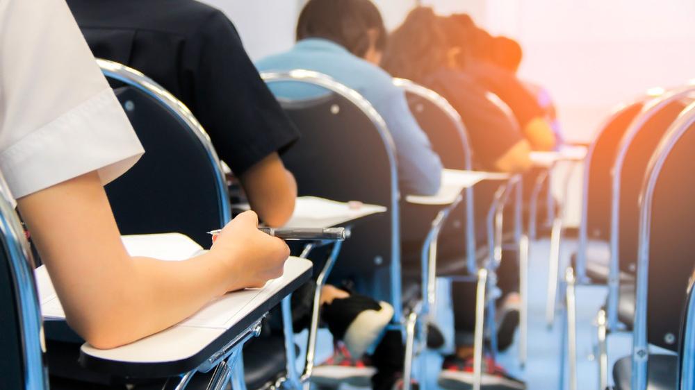 Estudantes respondem prova em sala de aula